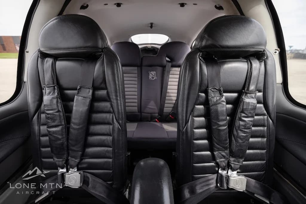 The black leather front seats of a Cirrus SR22 aircraft cabin, viewed from the rear.