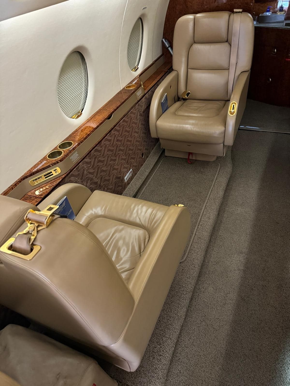 A view of the aircraft cabin seating with tan leather upholstery.