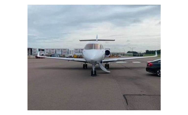 Front view of a Hawker jet parked on the tarmac with the stairs down.