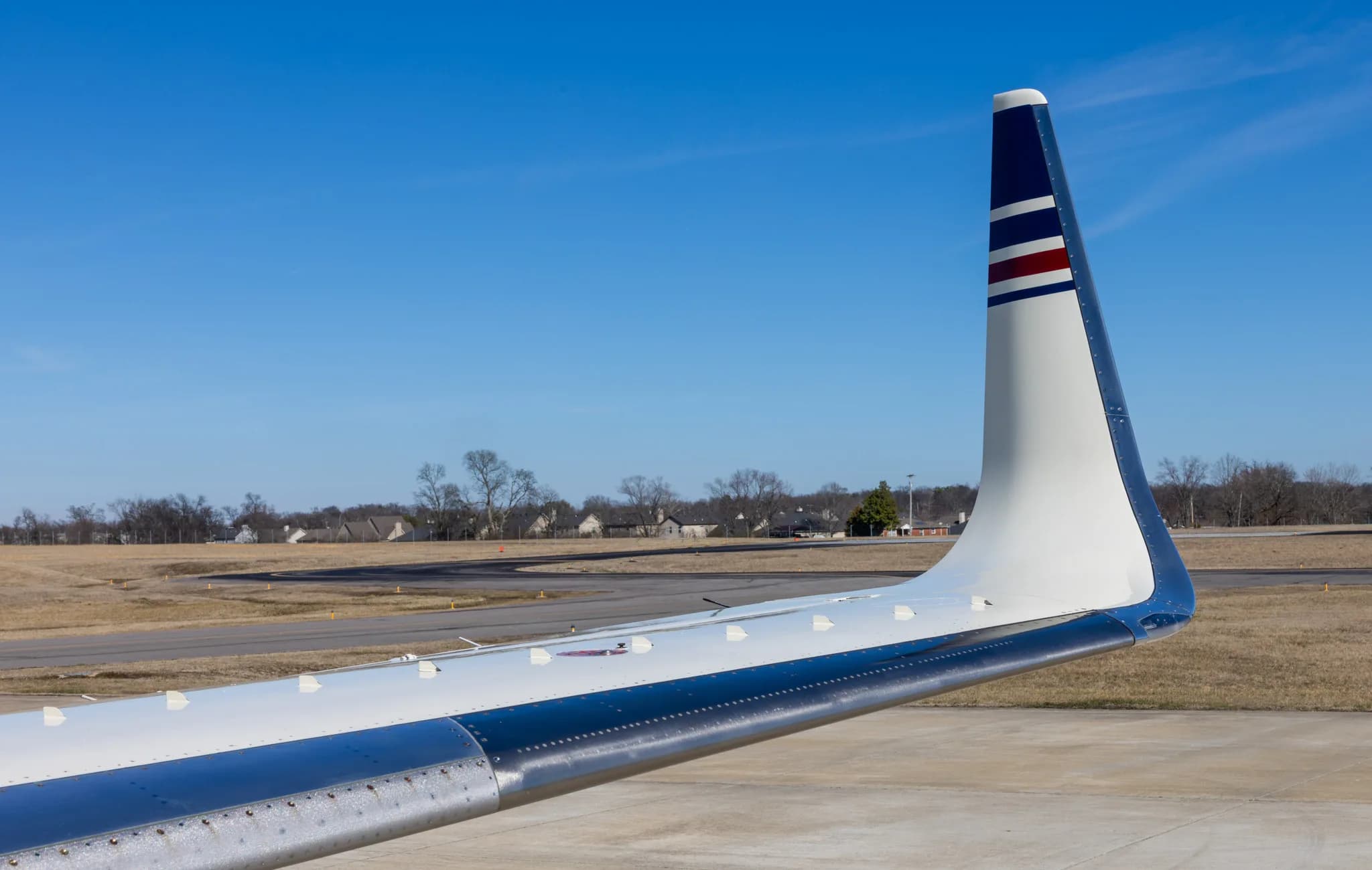 A close-up view of the white and blue winglet and wing of the N800UK business jet.