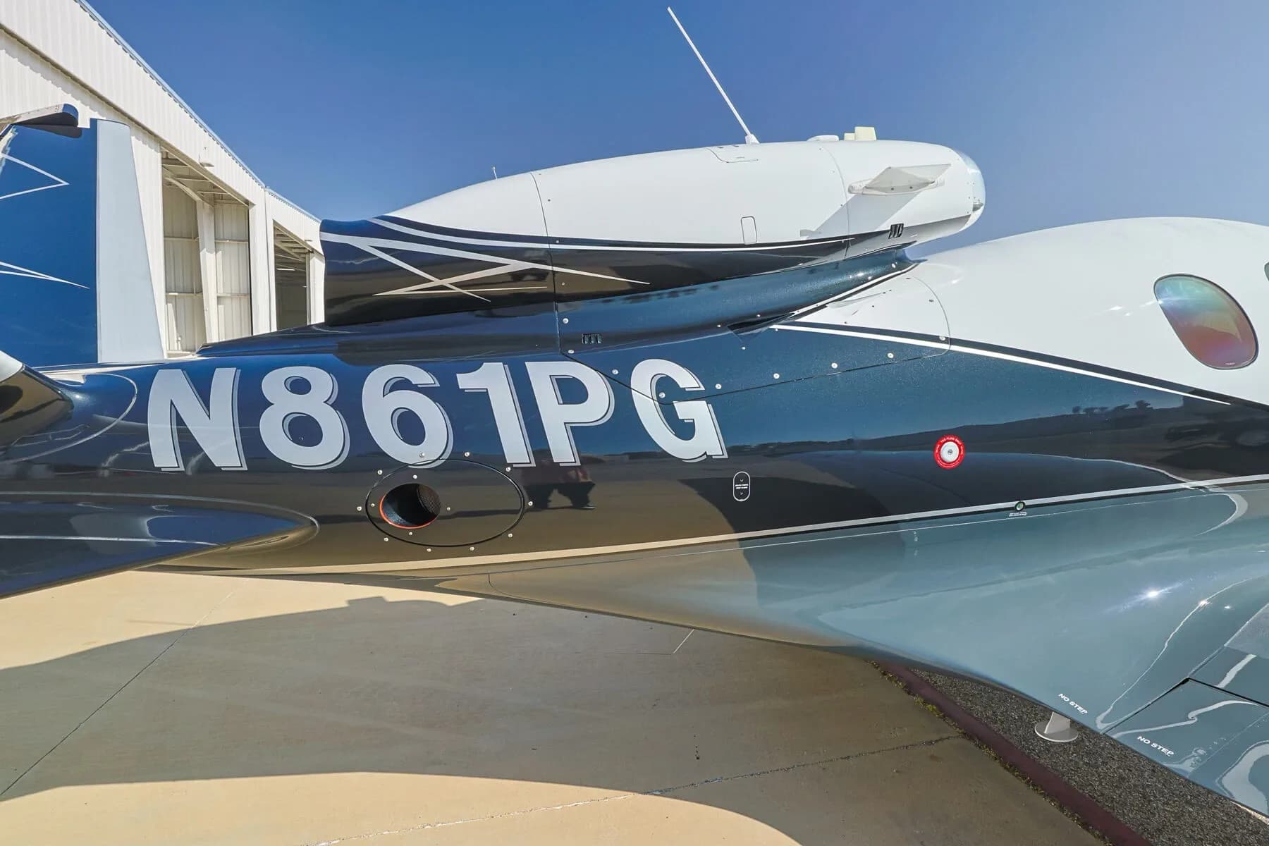 Close-up of the N-number "N861PG" on the fuselage of a Cirrus Vision Jet, showing the black and white paint scheme.