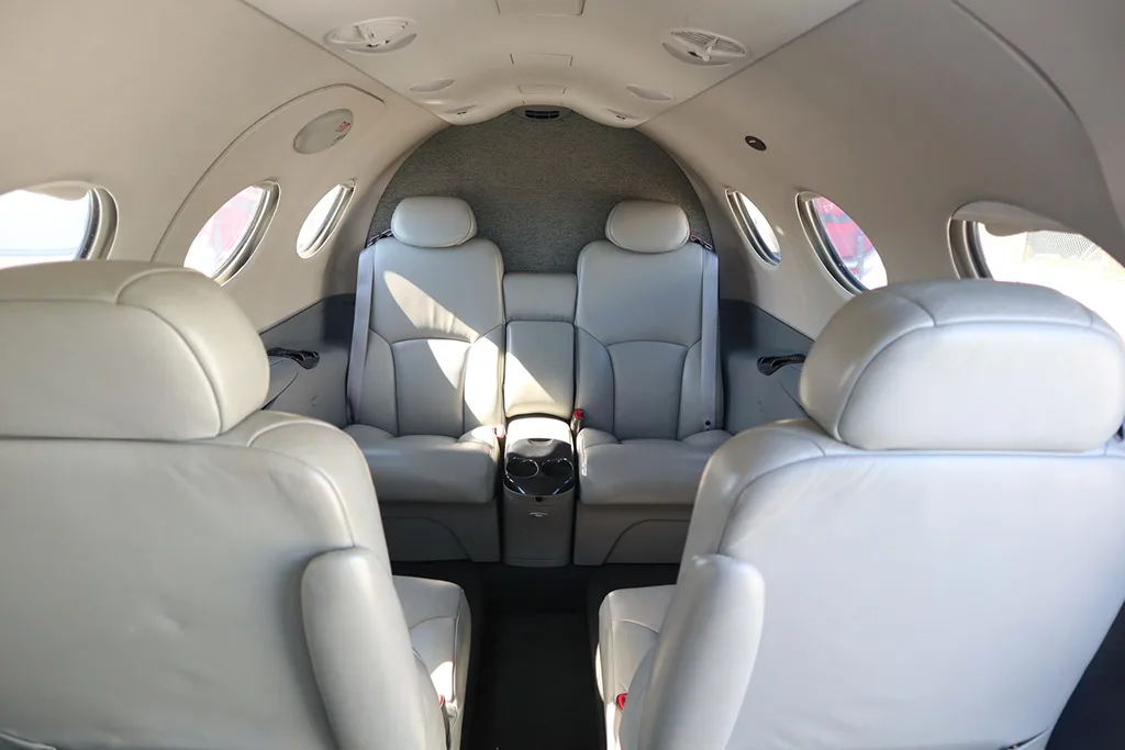 The light gray leather seats in the rear cabin of a private jet, facing forward.