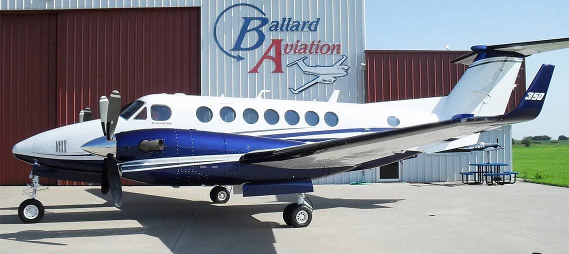 King Air 350 with blue and white paint scheme parked in front of a hangar.