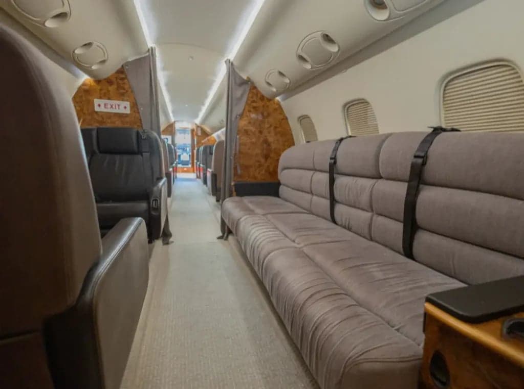 View of the interior cabin with a couch and seats.