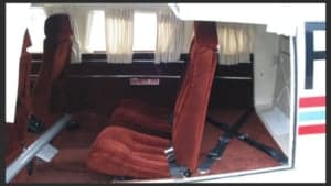 The interior of the aircraft featuring red seats and side paneling.