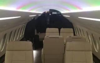 Interior view of the aircraft cabin with cream-colored leather seats.