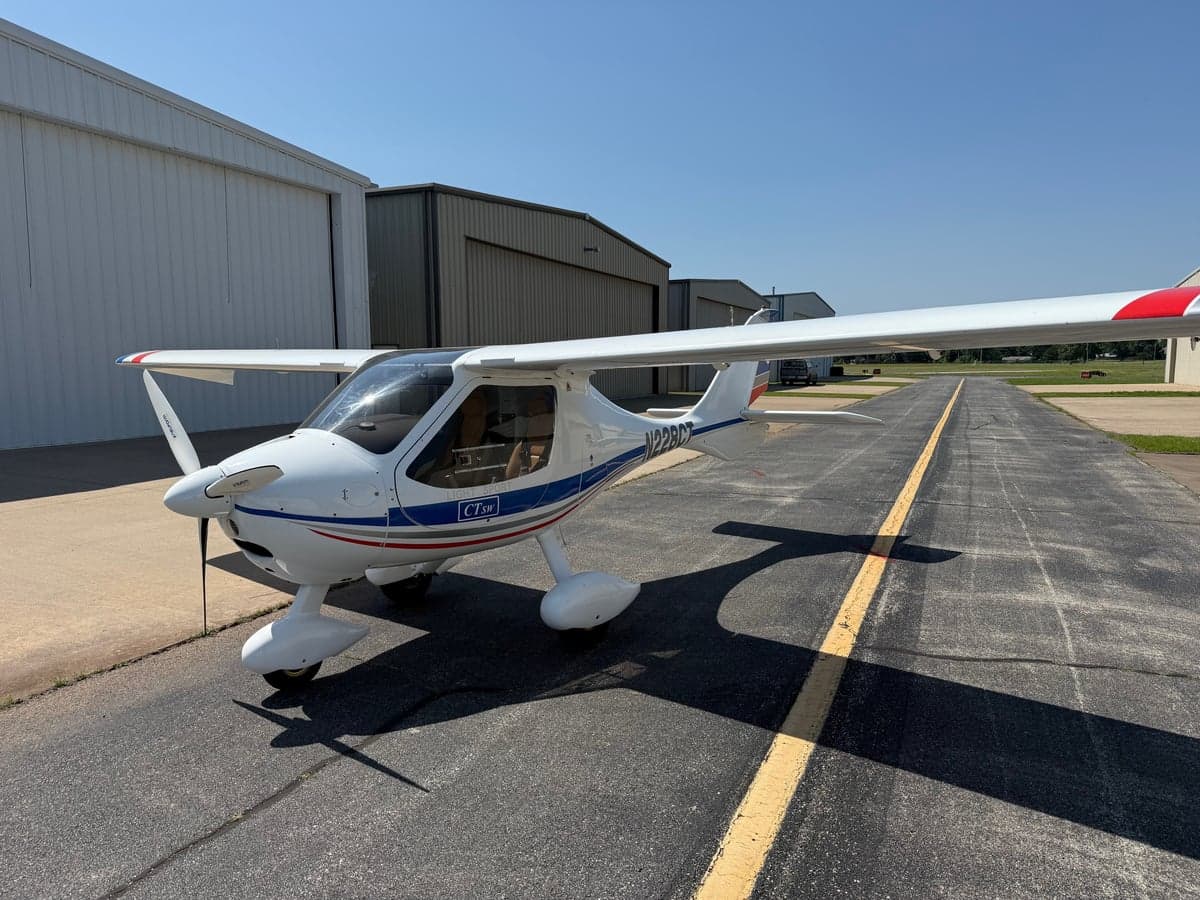 A CTLSW light sport aircraft is parked on the tarmac in front of a hangar.