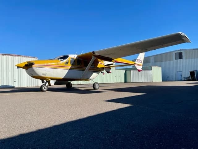 Side view of a yellow and white Cessna Skymaster N9GCX on the tarmac.