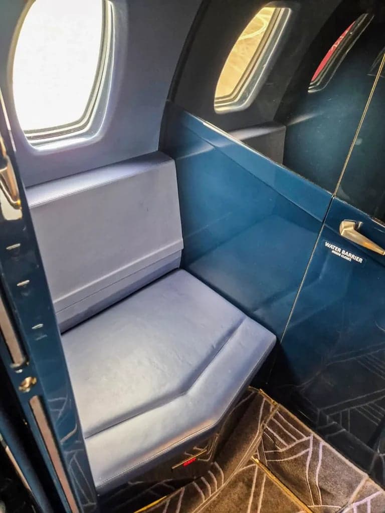 View of the aircraft's interior cabin with a blue leather seat.