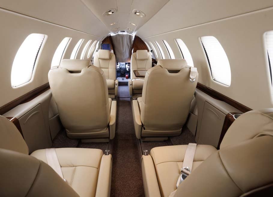 A view down the aisle of the aircraft cabin, showing the leather seats.