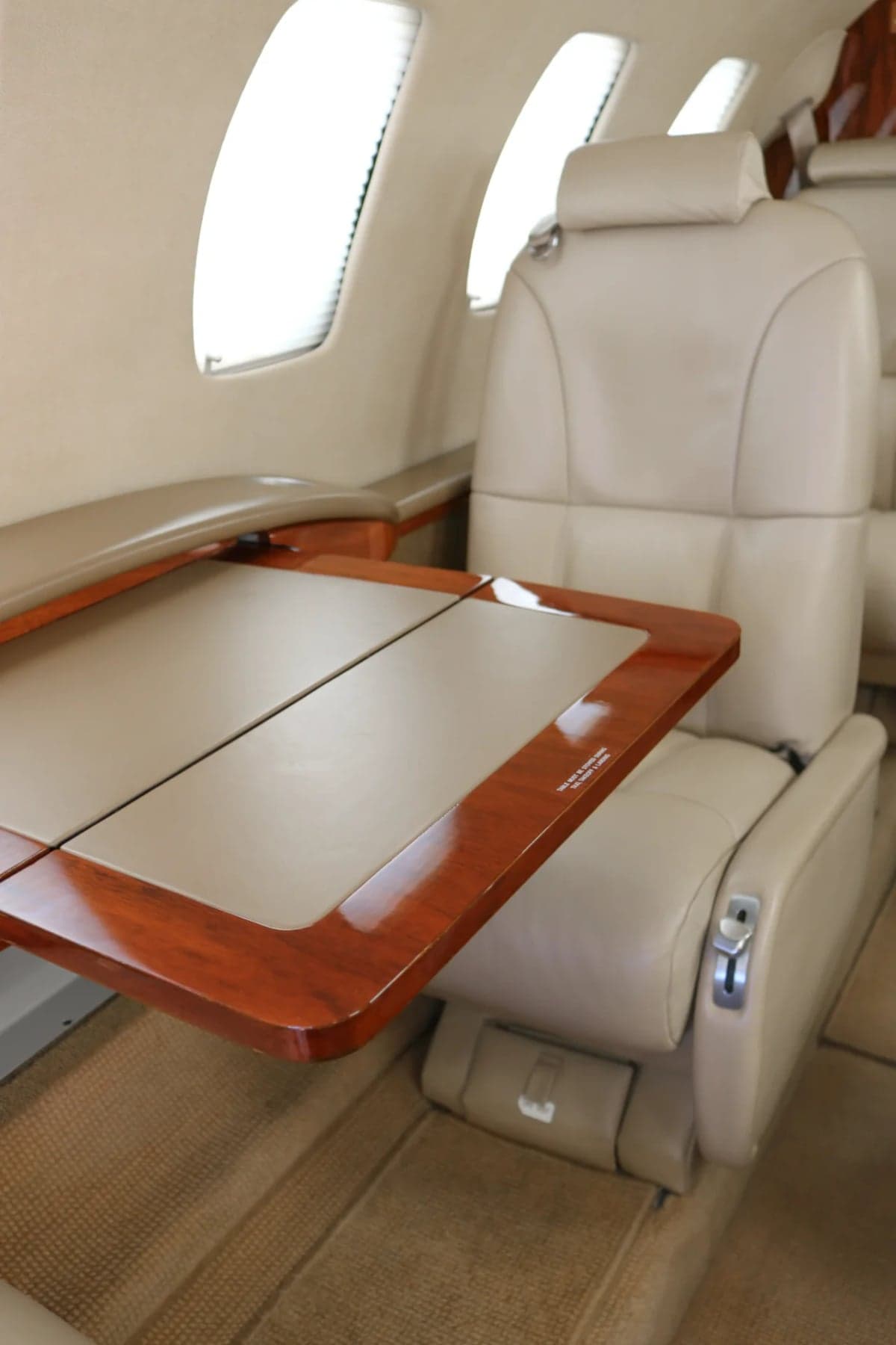 A Citation CJ2 cabin seat with a wooden table extended.