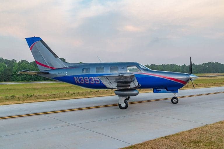Side view of a Piper Mirage N3935Y on the runway.