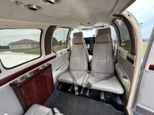 Interior view of the aircraft showing the cabin seats and a cabinet.