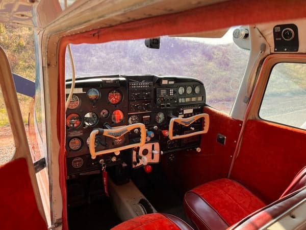 Wide view of the Cessna 210 cockpit, showing the instrument panel, seats, and interior.
