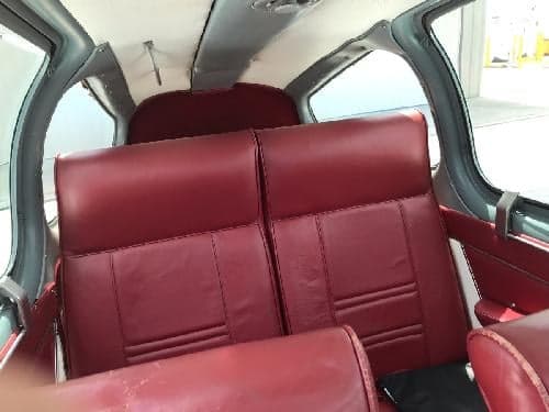 The interior of the aircraft features red leather seats.