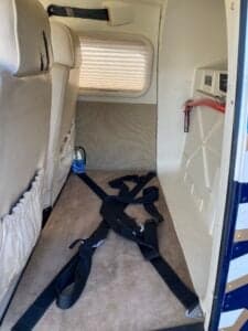 Rear cabin area of the aircraft with seatbelts on the floor.