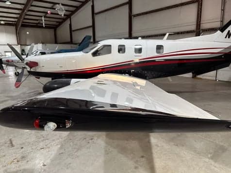 Side view of the TBM 850 aircraft in a hangar.