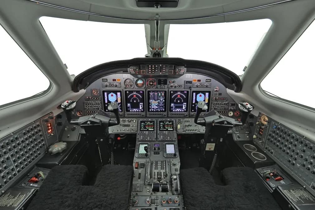 Aircraft cockpit instrument panel with multiple displays and controls.