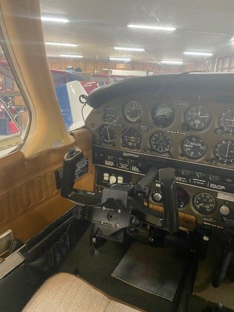 View of the aircraft's cockpit with the instrument panel and control yoke.