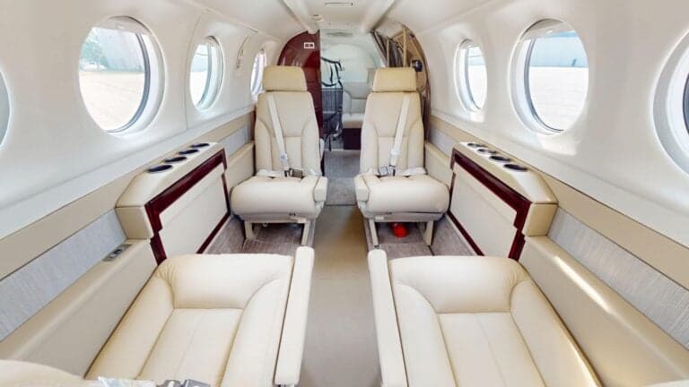 A King Air aircraft with an open door and airstair on the tarmac.