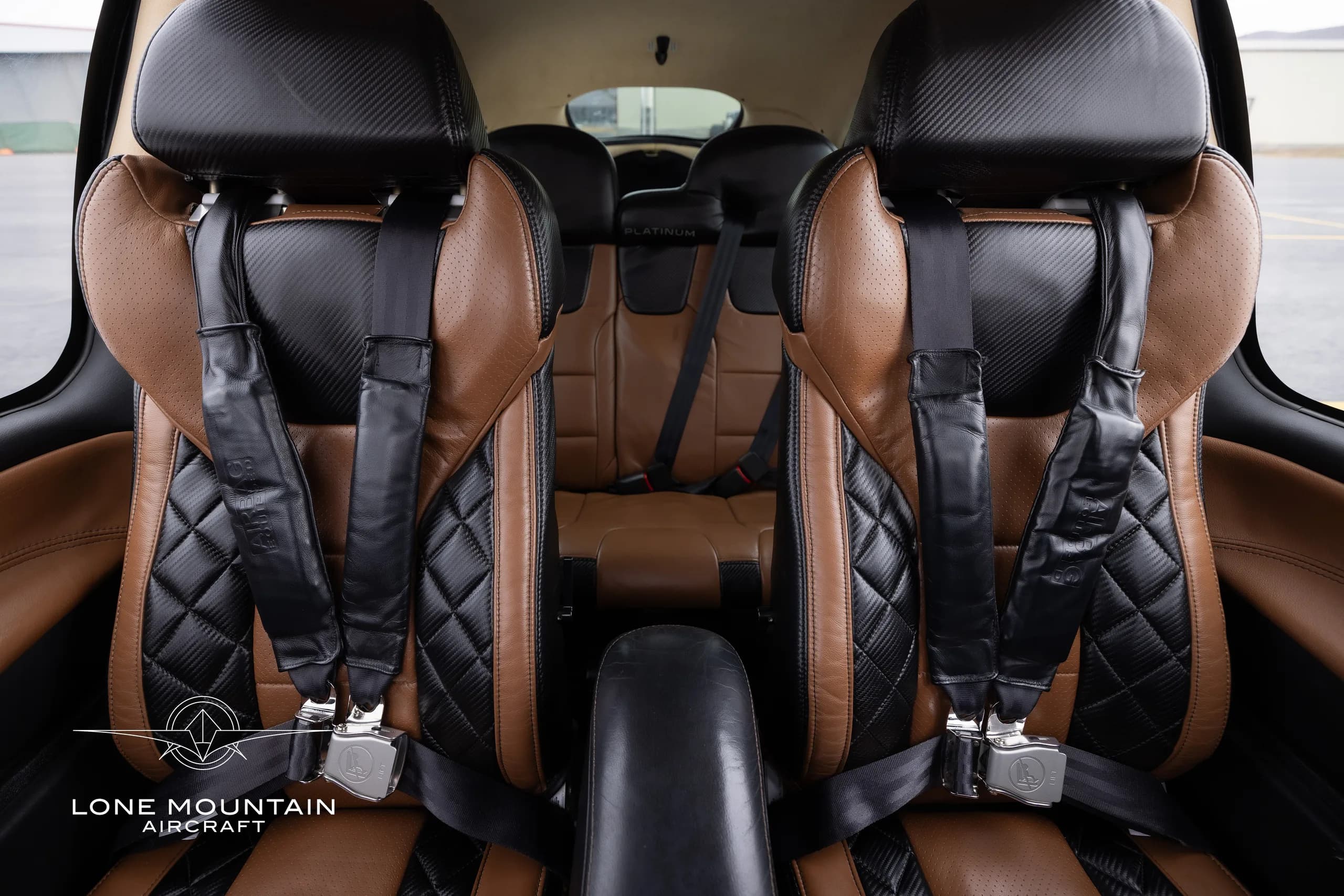 The interior of a Cirrus SR22T aircraft with brown and black leather seats.