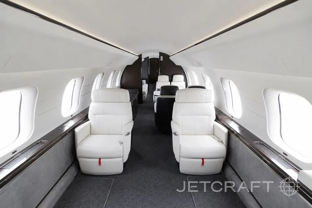 The luxurious white and dark grey cabin interior of a Bombardier Global 7500 with two forward-facing seats.
