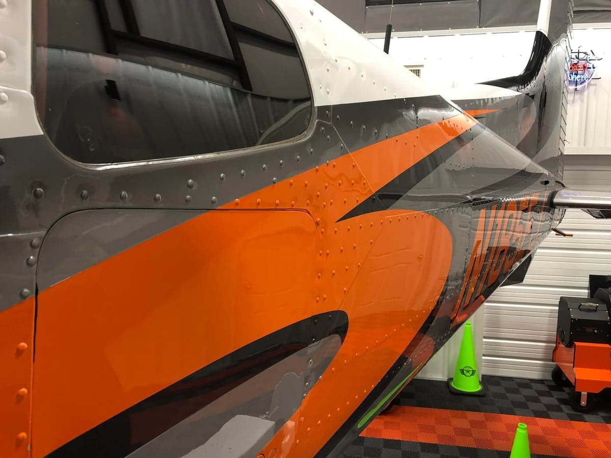 Close-up of the aircraft's tail section showing the gray, orange, and black paint scheme.