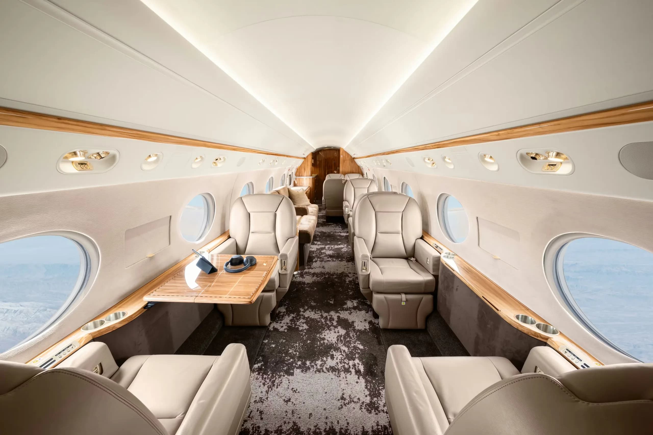 Interior view of the aircraft cabin with leather seats and a table.
