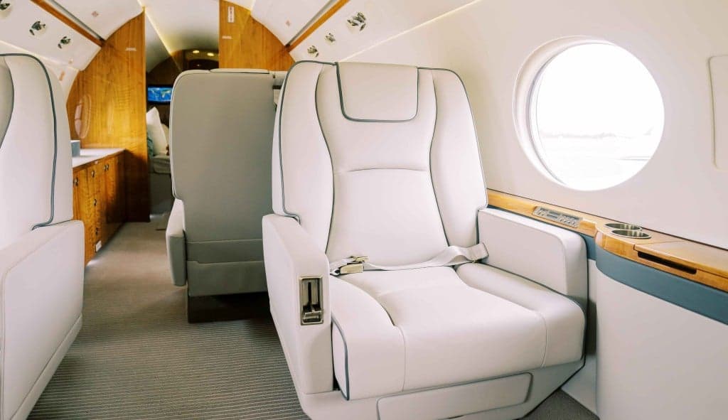 A white private jet parked on the tarmac.