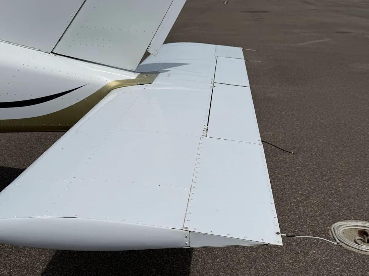 A close-up view of the white horizontal stabilizer and elevator of the Socata TB-20 Trinidad aircraft.