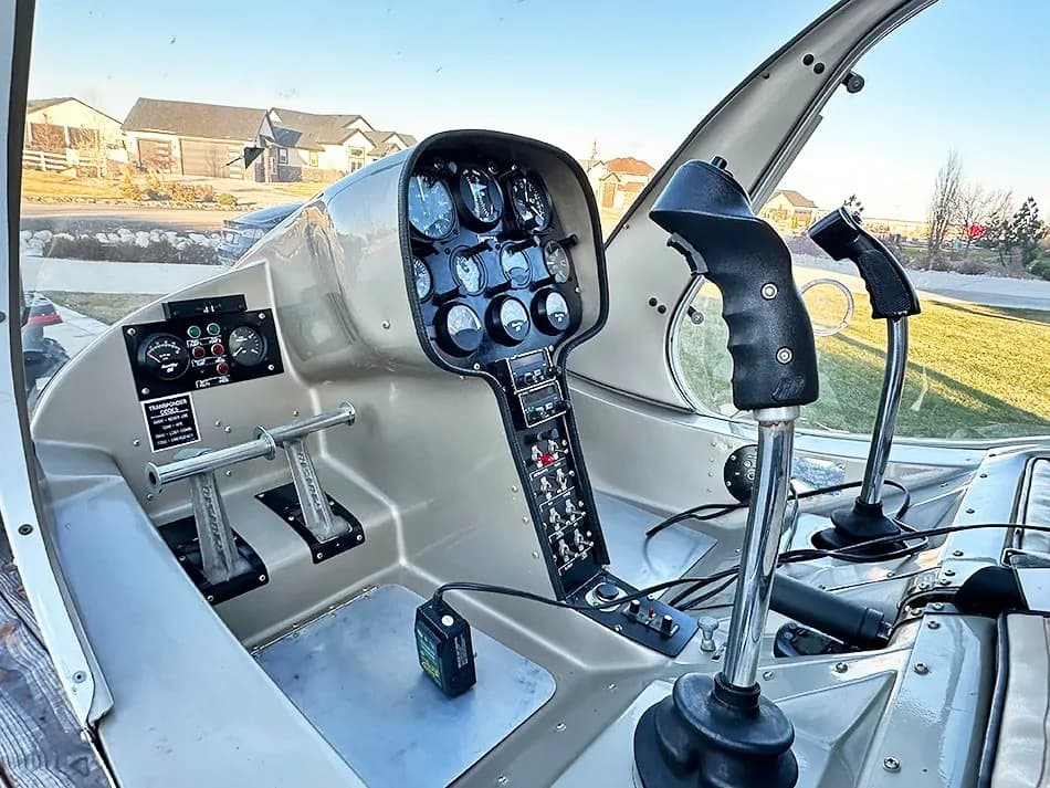 Cockpit view of the helicopter showing the instrument panel, cyclic, and collective controls.