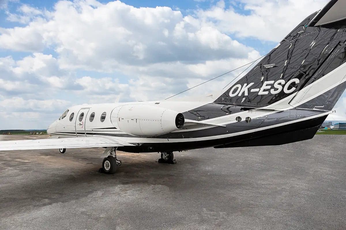 The tail section of the Nextant 400XT aircraft with registration OK-ESC is shown on the tarmac.