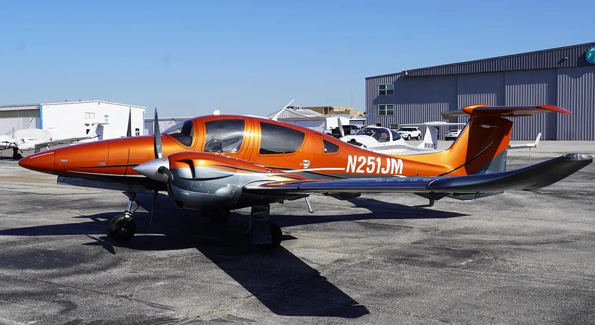 Side view of a Diamond DA62 aircraft with orange and gray paint scheme.
