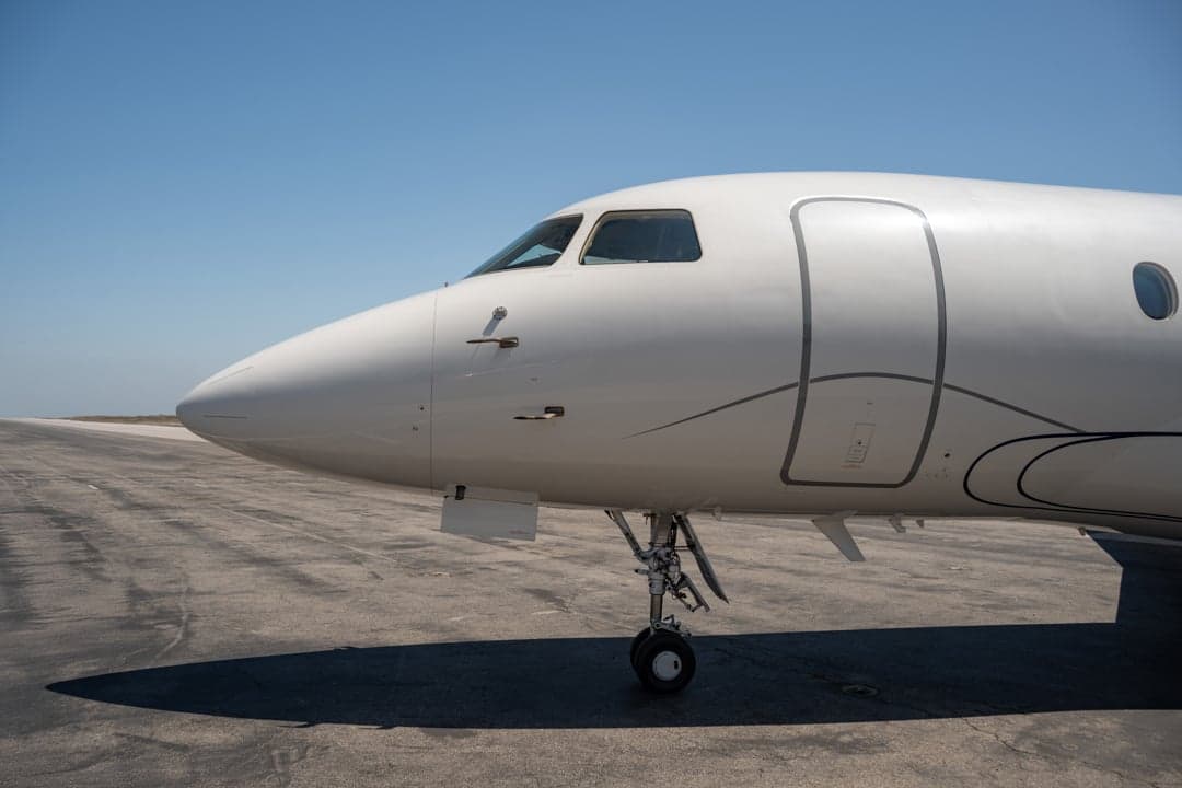 Close up of the nose of the white aircraft on the tarmac.