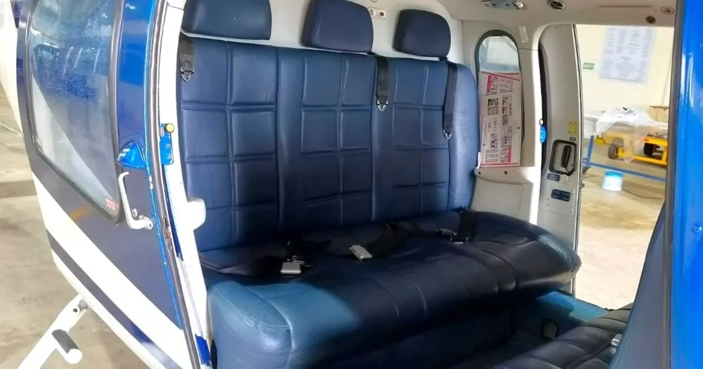 Close-up view of the blue leather rear passenger seats inside the helicopter cabin.