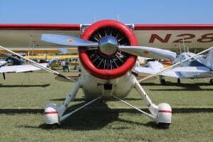 Front view of a Howard DGA-15P aircraft with a red engine cowling and silver propeller.