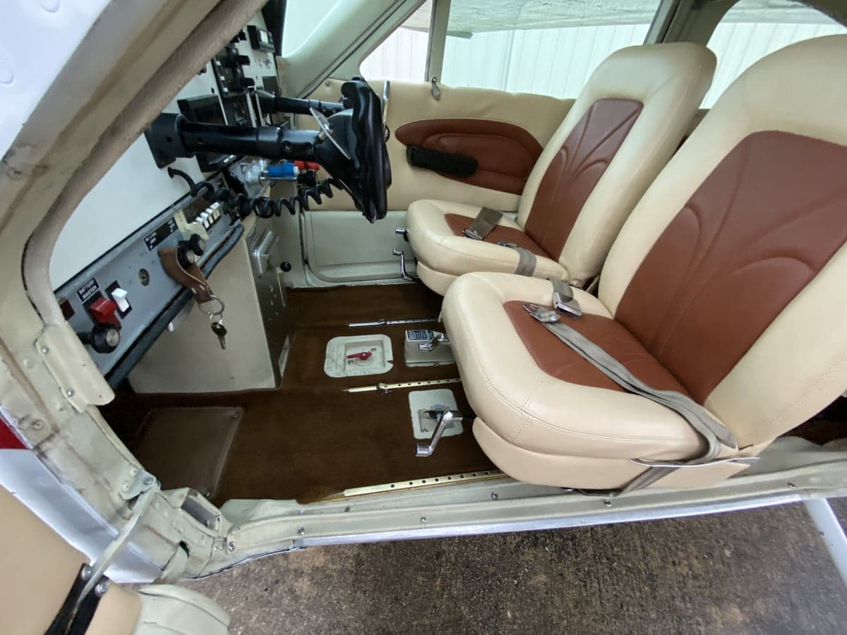 The interior of a Cessna 177RG Cardinal features tan and brown leather seats and brown carpeting.