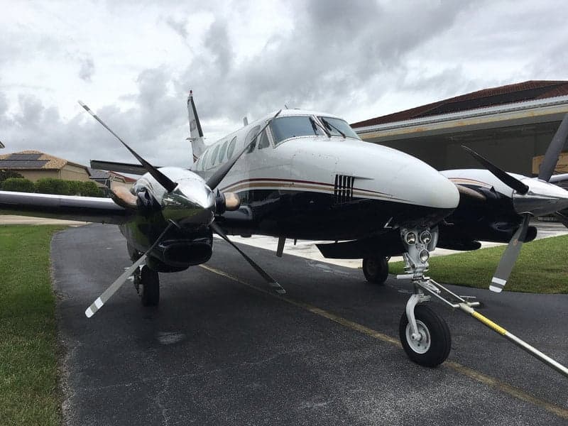 A close-up view of the Beechcraft King Air 90C, showcasing its nose, propellers, and landing gear.