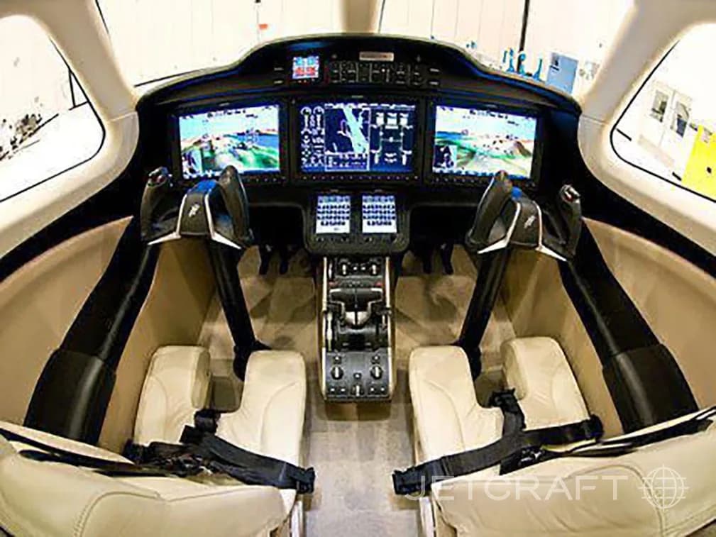 The cockpit of a HondaJet features three large display screens and two pilot seats.