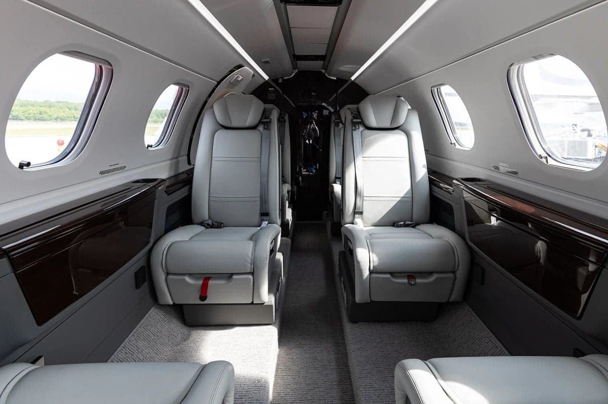 Interior view of a Cessna Citation Mustang cabin with gray leather seats.