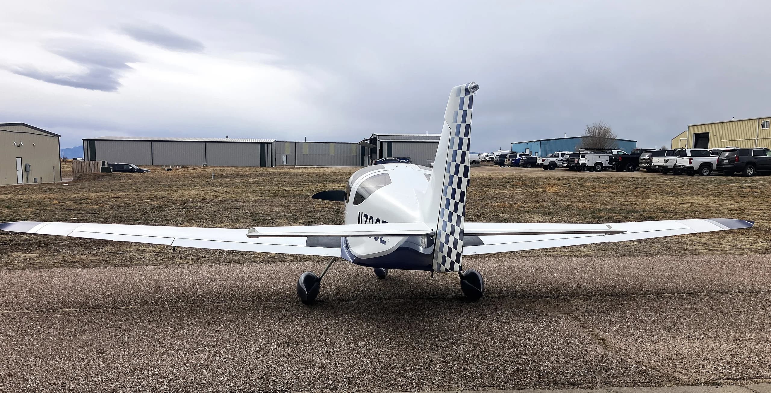 A white and blue Glasair Sportsman aircraft (N733Z) parked on an airfield, viewed from directly behind.