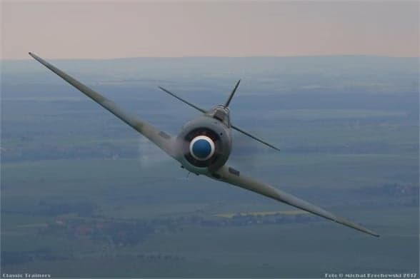 A Lavochkin La-9 in flight with a gray and green paint scheme and a red star on the tail.