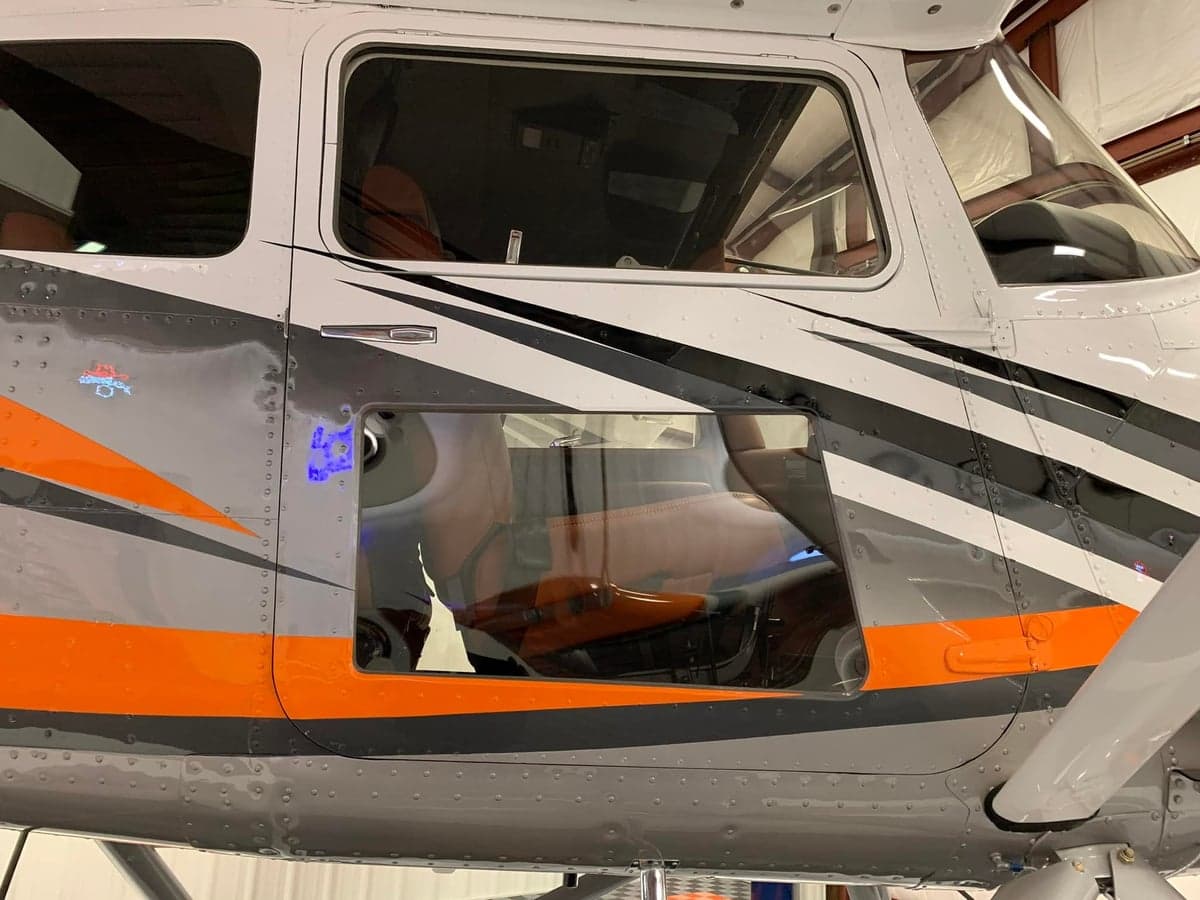 Close-up of the aircraft's exterior showing the gray, orange, and black paint scheme.
