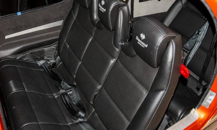 The interior of a Diamond DA62 aircraft features black leather seats with Diamond Aircraft logos.