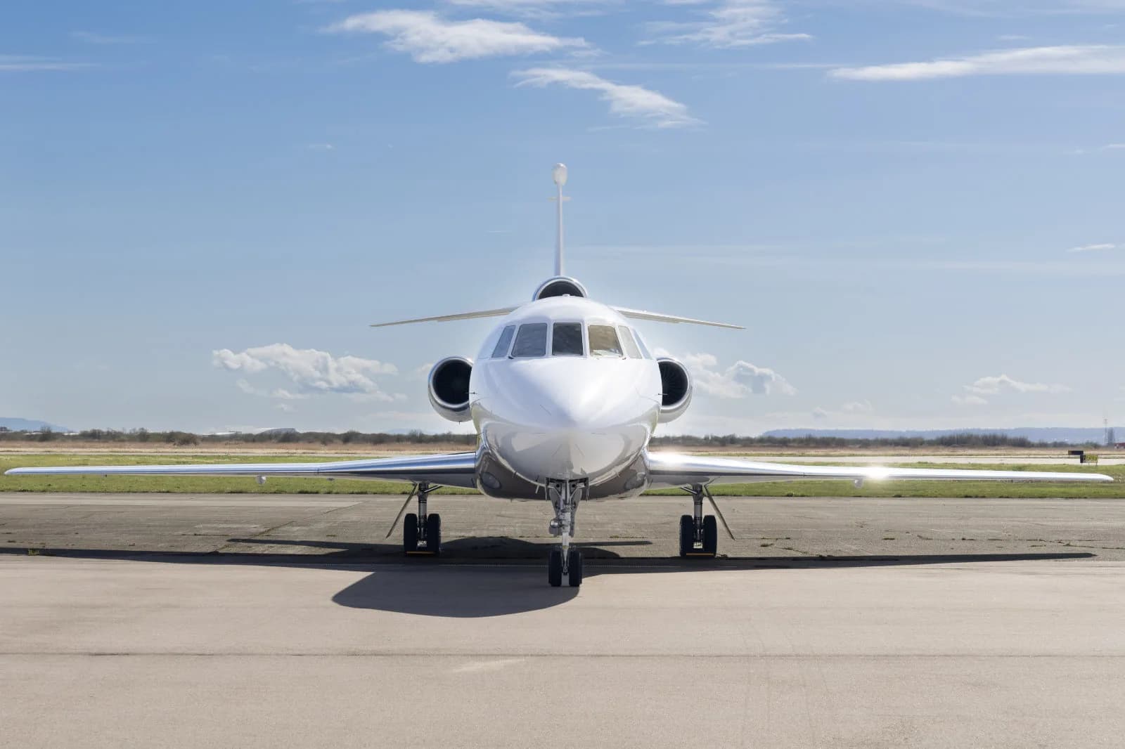 Front view of a white Falcon 2000 on the tarmac.