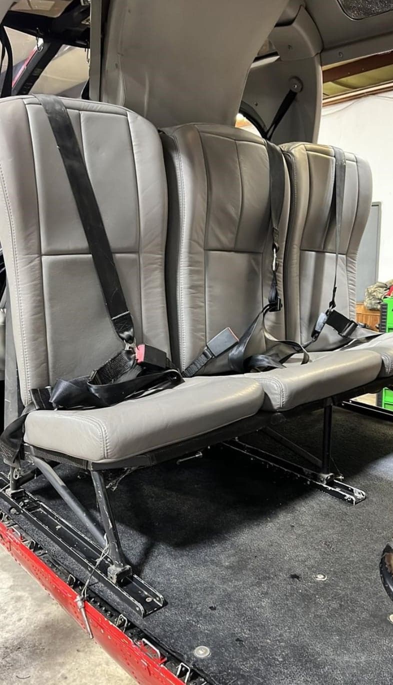 The gray leather seats inside the cabin of the helicopter.