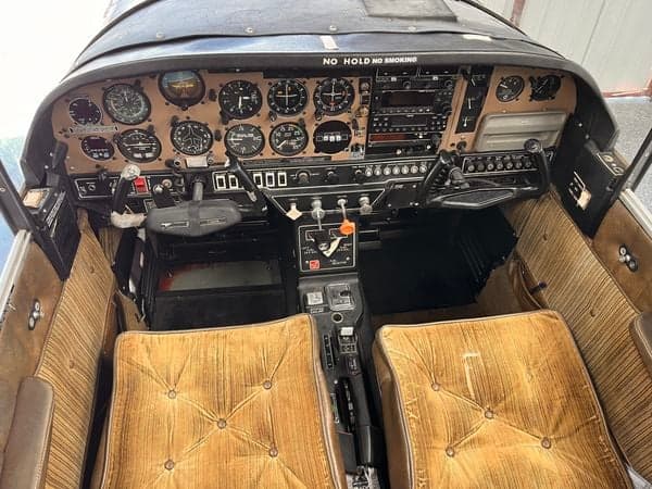 Wide view of the aircraft's cockpit instrument panel and seats.