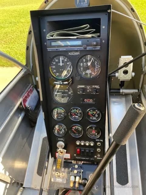 A close-up view of the black instrument panel inside the aircraft, showing various gauges and controls.