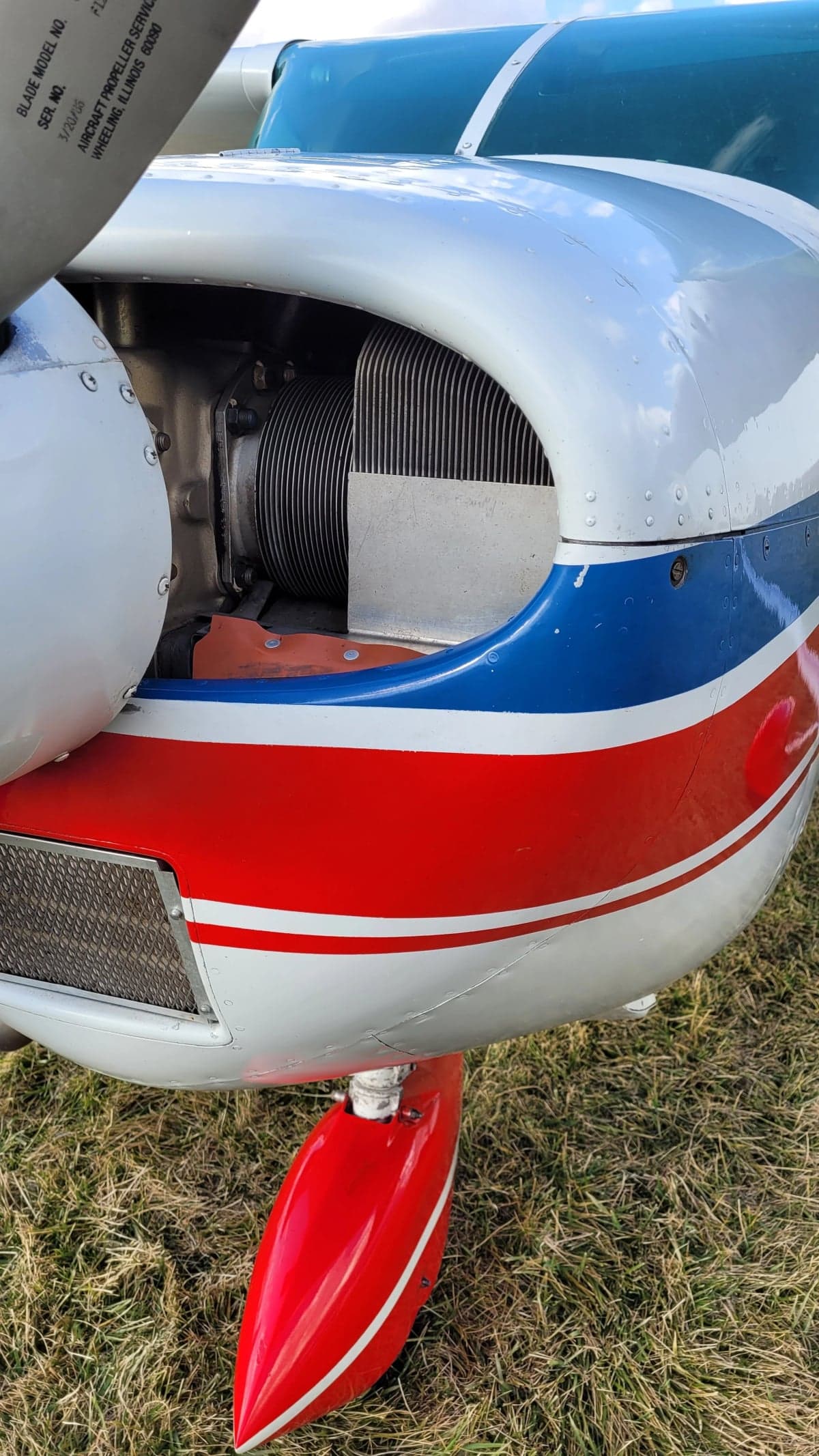 A close-up of the engine of the Cessna Skylane with red, white, and blue paint scheme.