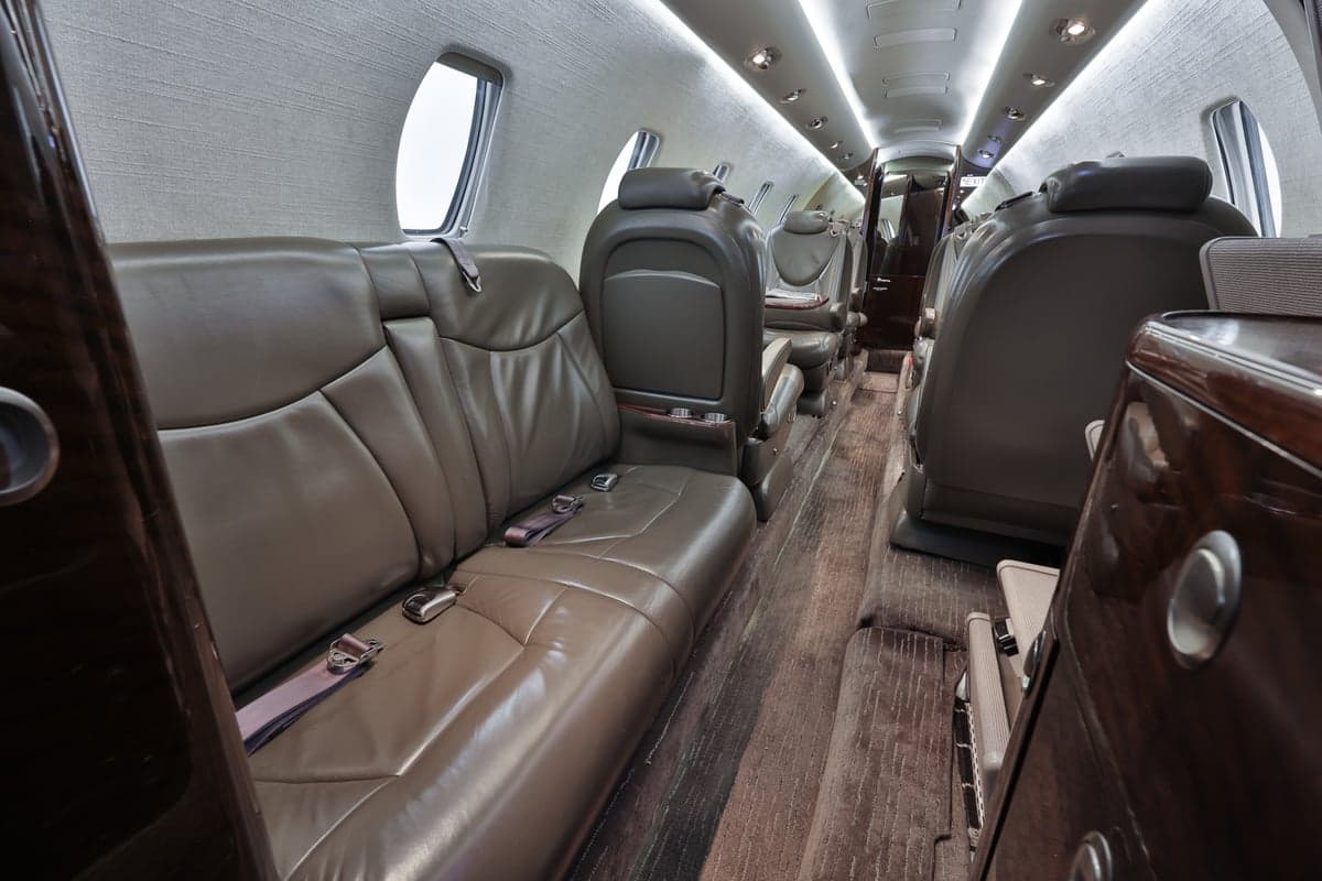 The Citation CJ3 cabin features leather seats and wood-grain accents.